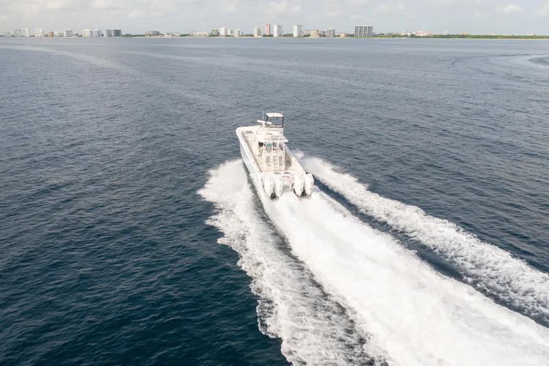 Seeking Twin Tales Yacht Photos Pics Invincible 46 Catamaran 2022 cruising on open water with city skyline in background.