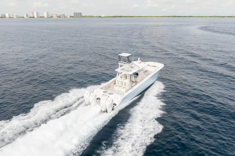 Seeking Twin Tales Yacht Photos Pics Invincible 46 Catamaran 2022 cruising on open water, city skyline in background.