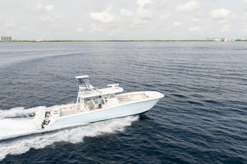 Seeking Twin Tales Yacht Photos Pics 2022 Invincible 46 Catamaran cruising on open water under a cloudy sky.