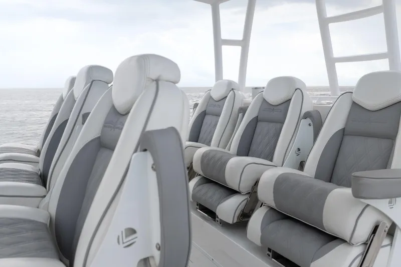 Seeking Twin Tales Yacht Photos Pics Luxurious seating on 2022 Invincible 46 Catamaran, featuring plush gray and white upholstery.