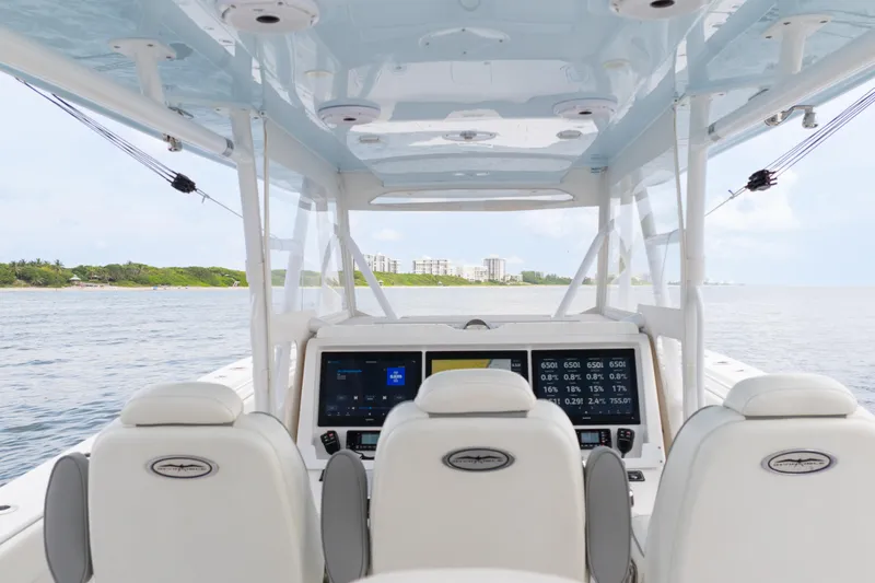 Seeking Twin Tales Yacht Photos Pics Interior view of 2022 Invincible 46 Catamaran with modern navigation screens and ocean backdrop.