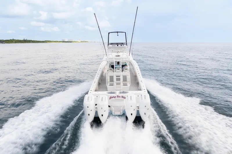 Seeking Twin Tales Yacht Photos Pics 2022 Invincible 46 Catamaran cruising on open water, rear view.