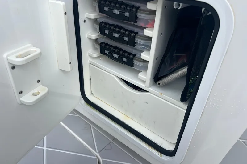 Seeking Twin Tales Yacht Photos Pics Storage compartment on a 2022 Invincible 46 Catamaran, featuring organized tackle boxes.