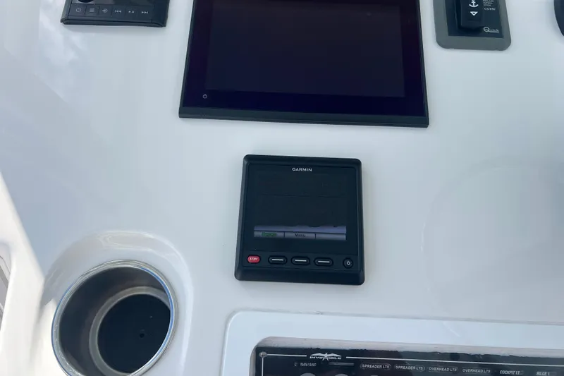 Seeking Twin Tales Yacht Photos Pics Control panel of 2022 Invincible 46 Catamaran featuring Garmin display and cup holder.