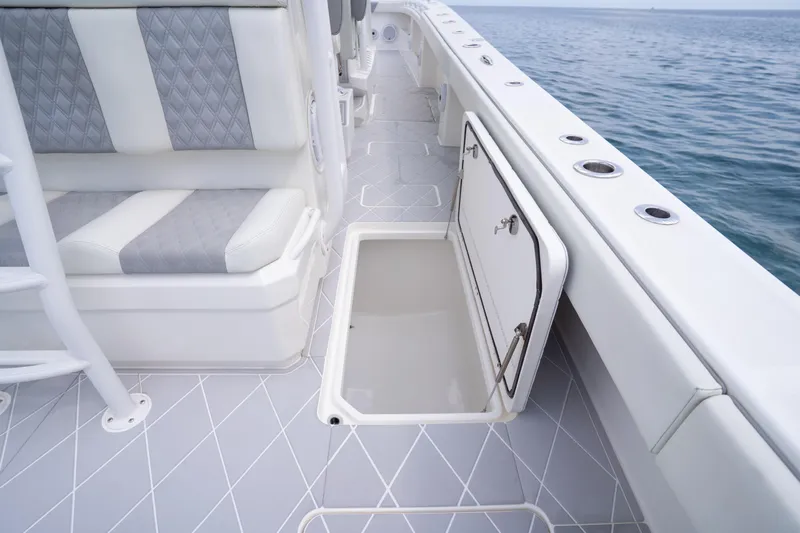 Seeking Twin Tales Yacht Photos Pics Invincible 46 Catamaran 2022 deck with open storage compartment and cushioned seating.