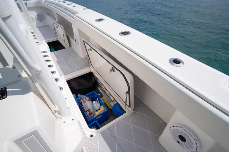 Seeking Twin Tales Yacht Photos Pics 2022 Invincible 46 Catamaran storage compartment with ocean view, showcasing organized equipment.