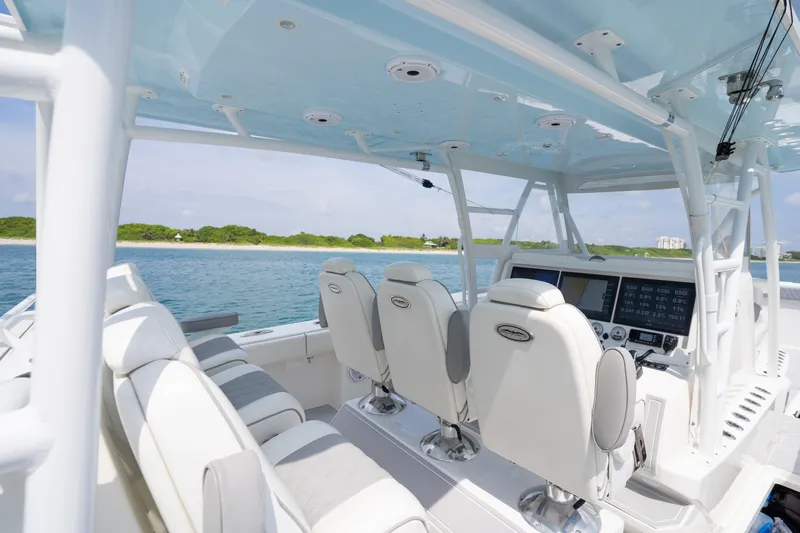 Seeking Twin Tales Yacht Photos Pics Interior view of 2022 Invincible 46 Catamaran with modern seating and navigation equipment.