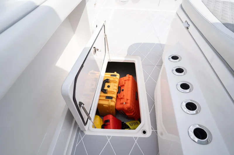 Seeking Twin Tales Yacht Photos Pics Open storage compartment on 2022 Invincible 46 Catamaran with safety equipment inside.