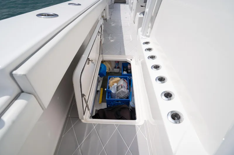 Seeking Twin Tales Yacht Photos Pics Storage compartment on 2022 Invincible 46 Catamaran, featuring organized fishing gear and accessories.