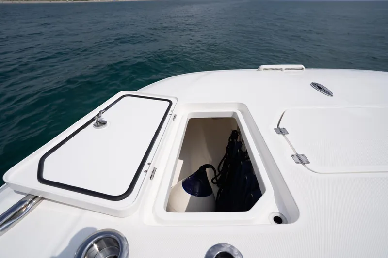 Seeking Twin Tales Yacht Photos Pics Open storage compartment on 2022 Invincible 46 Catamaran, with ocean backdrop.