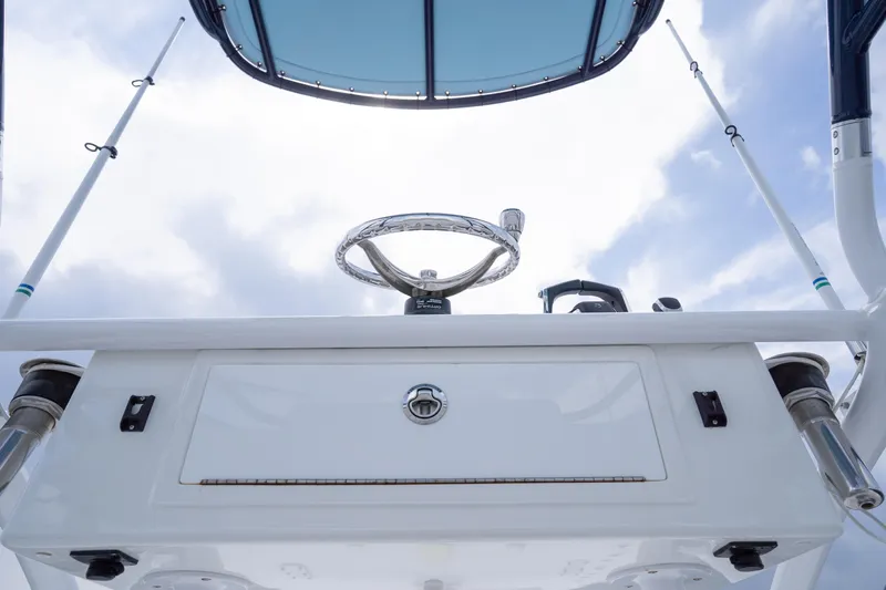 Seeking Twin Tales Yacht Photos Pics 2022 Invincible 46 Catamaran helm with steering wheel and fishing rod holders.