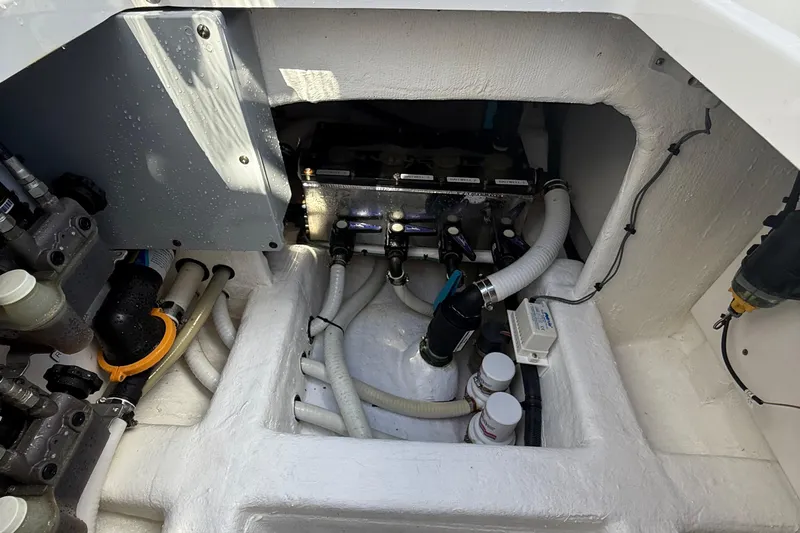 Seeking Twin Tales Yacht Photos Pics Engine compartment of 2022 Invincible 46 Catamaran, showcasing hoses and mechanical components.