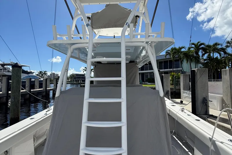 Seeking Twin Tales Yacht Photos Pics 2022 Invincible 46 Catamaran docked, featuring a ladder and covered seating area.