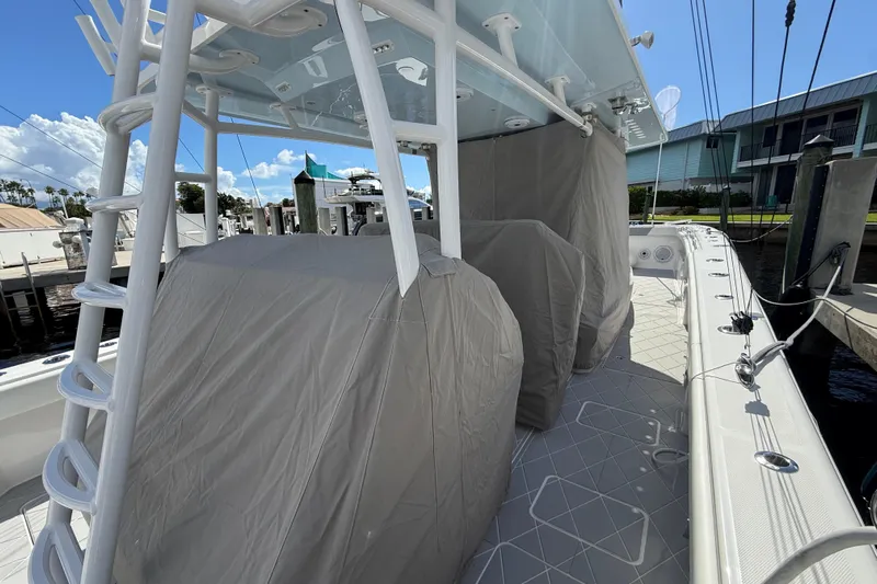 Seeking Twin Tales Yacht Photos Pics 2022 Invincible 46 Catamaran docked, featuring covered seating and modern design.