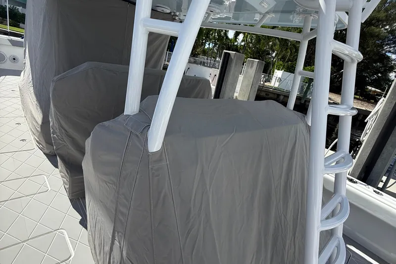 Seeking Twin Tales Yacht Photos Pics 2022 Invincible 46 Catamaran with covered seating and ladder, docked in a marina.