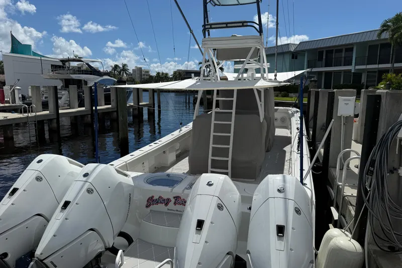 Seeking Twin Tales Yacht Photos Pics 2022 Invincible 46 Catamaran docked, featuring multiple outboard engines and a spacious deck.