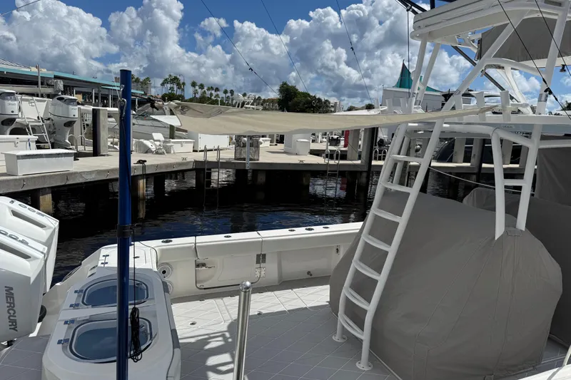 Seeking Twin Tales Yacht Photos Pics 2022 Invincible 46 Catamaran docked, showcasing deck and ladder under a cloudy sky.