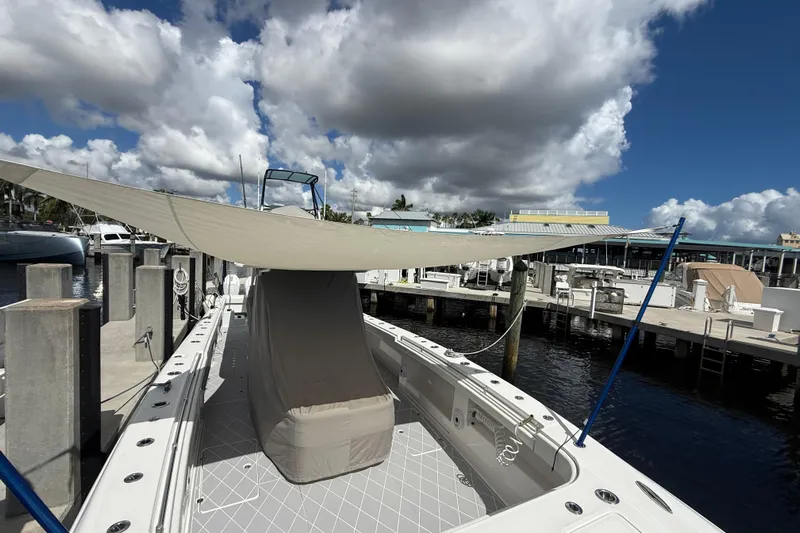 Seeking Twin Tales Yacht Photos Pics 2022 Invincible 46 Catamaran docked with sunshade under cloudy sky.