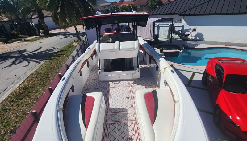  Yacht Photos Pics 2012 Deep Impact 36 Cuddy Cabin boat parked near a pool and red car.