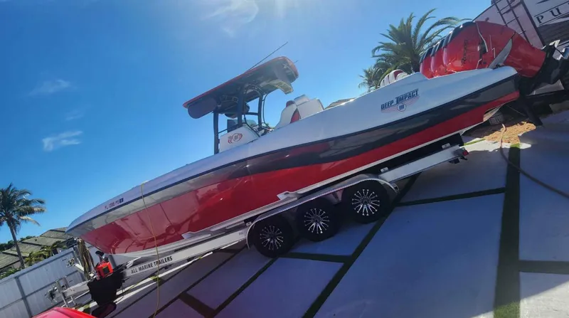  Yacht Photos Pics 2012 Deep Impact 36 Cuddy Cabin boat on trailer, red and white design, sunny day.