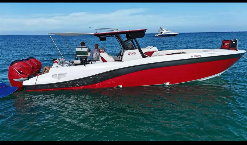  Yacht Photos Pics 2012 Deep Impact 36 Cuddy Cabin boat with red hull on open water.