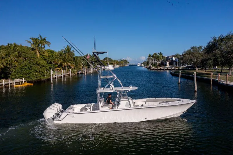  Yacht Photos Pics 2022 SeaVee 390Z boat cruising on a scenic canal with clear blue skies.