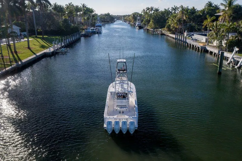  Yacht Photos Pics 2022 SeaVee 390Z boat cruising through a scenic canal lined with palm trees.