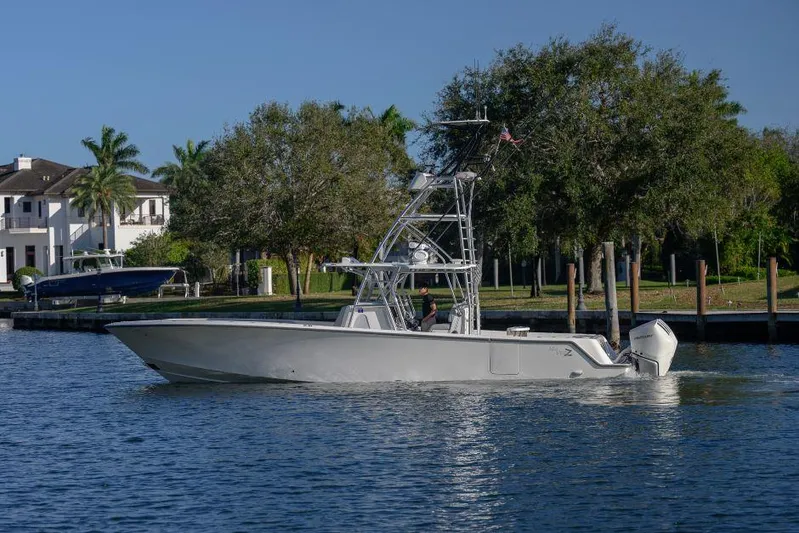  Yacht Photos Pics 2022 SeaVee 390Z boat cruising on a calm waterway near a residential area.