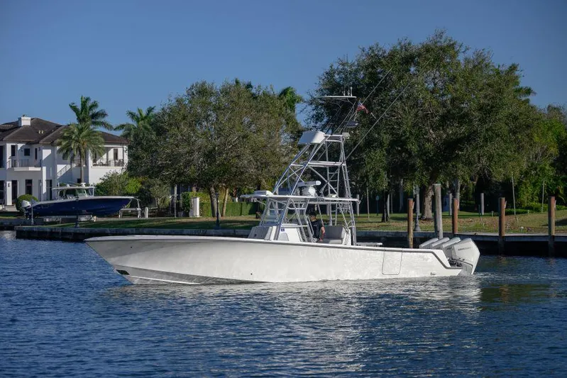  Yacht Photos Pics 2022 SeaVee 390Z boat on calm water near a residential area with trees.