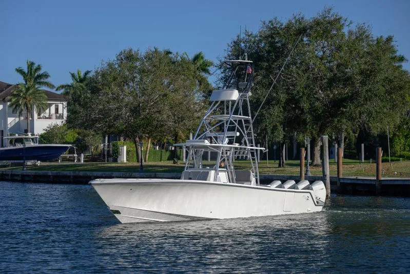  Yacht Photos Pics 2022 SeaVee 390Z boat on a calm waterway, surrounded by trees and docks.