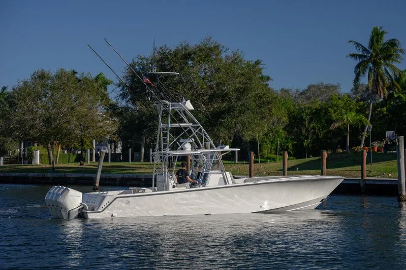 Yacht Photos Pics 2022 SeaVee 390Z boat cruising on a calm waterway with lush greenery in the background.