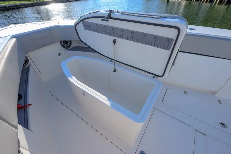  Yacht Photos Pics 2022 SeaVee 390Z boat with open storage compartment, docked by the water.