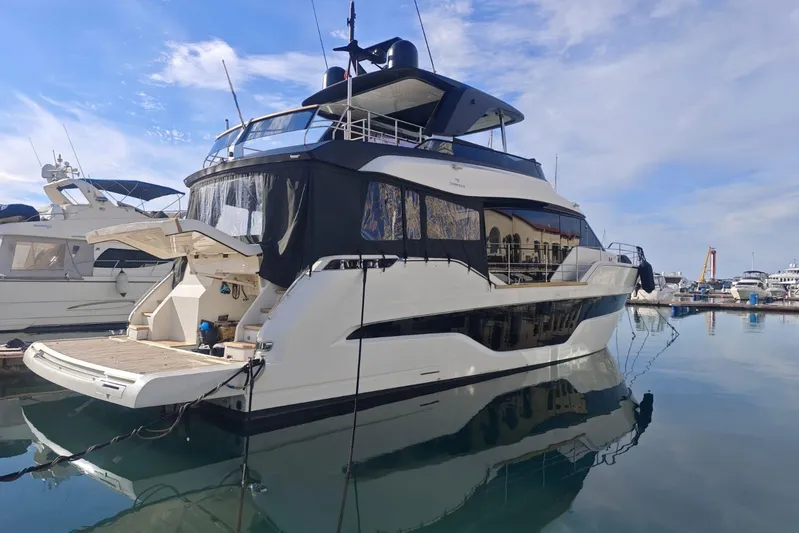 Arktur Yacht Photos Pics Luxury 2023 Cranchi Sessantasette 67 yacht docked in a serene marina setting.