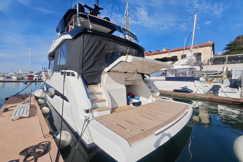 Arktur Yacht Photos Pics 2023 Cranchi Sessantasette 67 yacht docked at marina under clear blue sky.