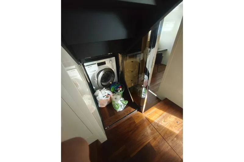 Arktur Yacht Photos Pics Laundry area inside 2023 Cranchi Sessantasette 67 yacht with washing machine and storage.