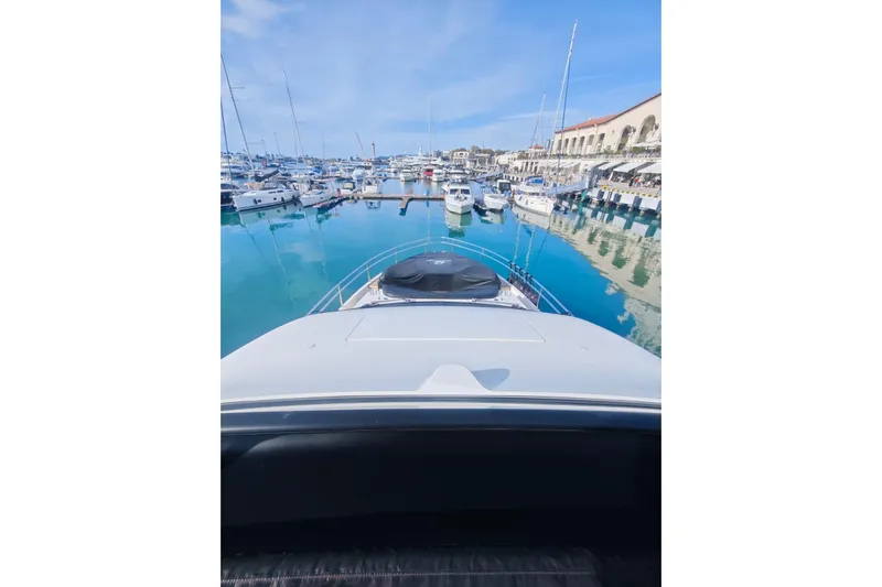 Arktur Yacht Photos Pics 2023 Cranchi Sessantasette 67 yacht docked in a marina with clear blue water.