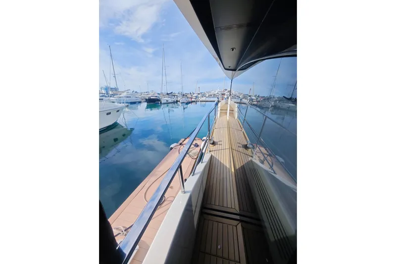 Arktur Yacht Photos Pics 2023 Cranchi Sessantasette 67 yacht docked in a serene marina setting.