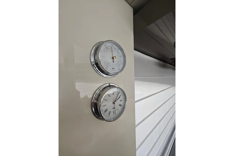 Arktur Yacht Photos Pics Chrome gauges on Cranchi Sessantasette 67 yacht, 2023 model, displaying time and atmospheric pressure.