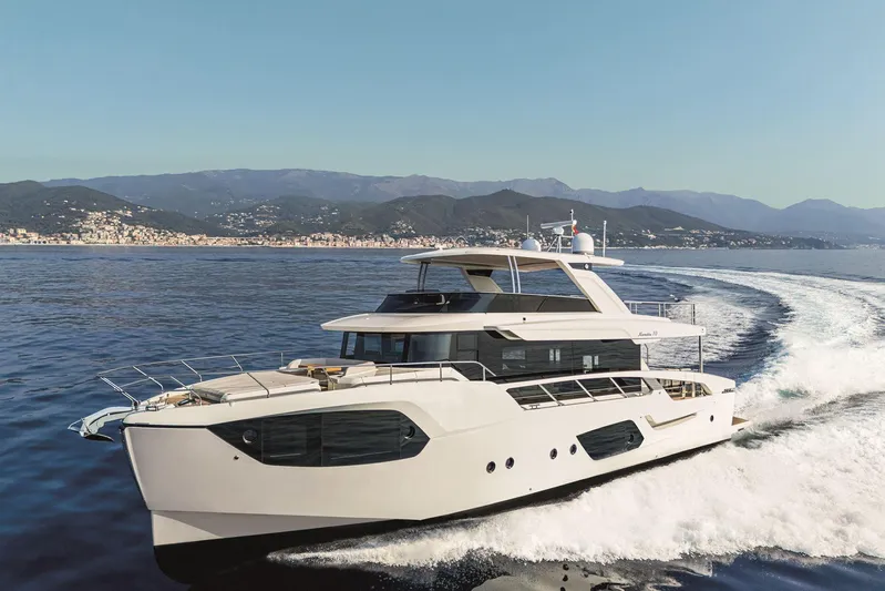  Yacht Photos Pics 2026 Absolute NAVETTA 70 yacht cruising on open water with scenic coastal backdrop.