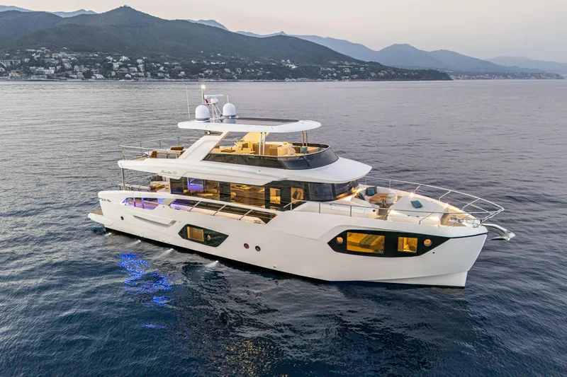  Yacht Photos Pics Luxurious 2026 Absolute NAVETTA 70 yacht cruising on serene waters at sunset.
