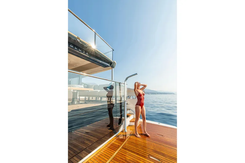  Yacht Photos Pics Woman enjoying sun on Absolute NAVETTA 70 yacht, 2026 model, with ocean view.