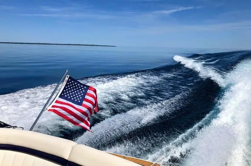 Down Time Yacht Photos Pics Sea Ray 500 Sundancer 2010 cruising with American flag on calm waters.