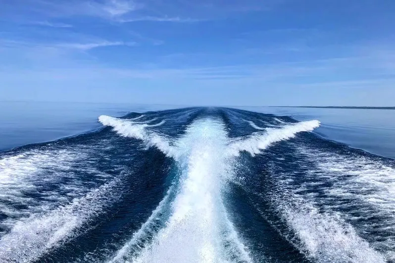 Down Time Yacht Photos Pics Wake of a 2010 Sea Ray 500 Sundancer on a calm ocean.