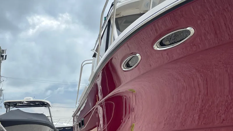  Yacht Photos Pics 2018 Cutwater C-30 Command Bridge LE boat with red hull, docked under cloudy sky.