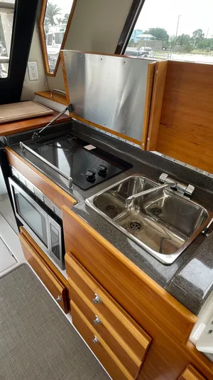  Yacht Photos Pics 2018 Cutwater C-30 Command Bridge LE kitchen with stove, sink, and microwave.