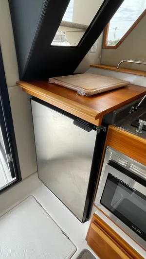  Yacht Photos Pics 2018 Cutwater C-30 Command Bridge LE galley with stainless steel fridge and wooden countertop.