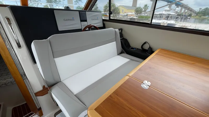  Yacht Photos Pics Interior of 2018 Cutwater C-30 Command Bridge LE with seating and wooden table.