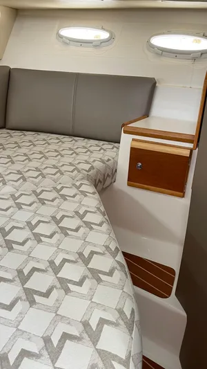  Yacht Photos Pics 2018 Cutwater C-30 Command Bridge LE cabin interior with patterned bedding and wooden accents.