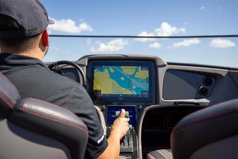  Yacht Photos Pics Person navigating MTI 390X boat with advanced touchscreen display, 2024 model.