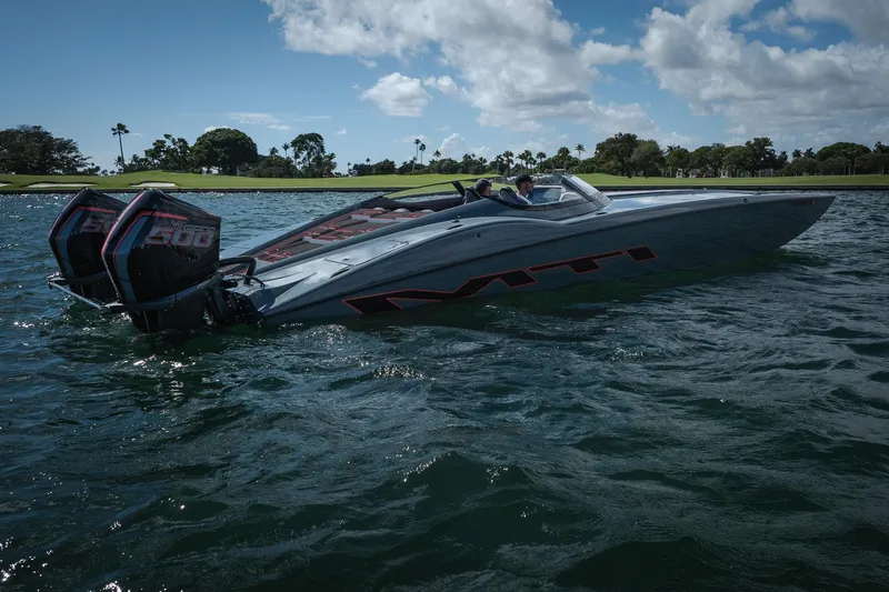  Yacht Photos Pics 2024 MTI 390X speedboat on water, featuring dual outboard engines, under a partly cloudy sky.